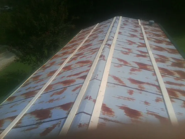 Rusted metal roof panels with new wood purlins before replacement — Storm Damage Roof Repair in Britt by Roofing Brothers